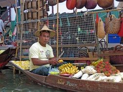 man on a boat in a floating market
