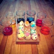 cute painted eggs and jars on wooden table, easter still life