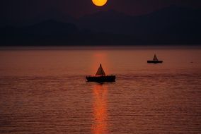 boats at sea during sunset