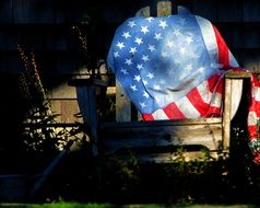 famerican lag on old armchair at summer night outdoor