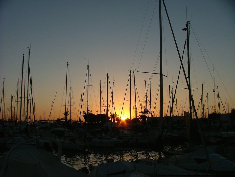 sunset over the boats on the pier in La Manga