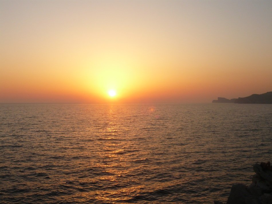 sun on a yellow sky on the horizon of the sea