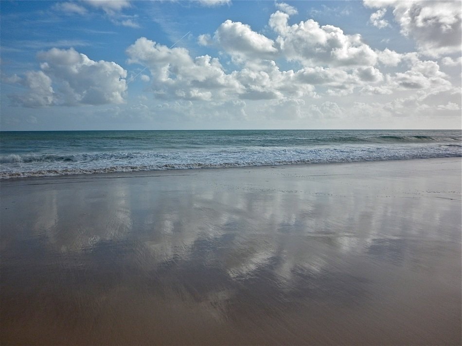 reflection of clouds on the beach of the sea