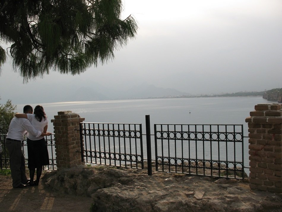 couple in love stands near the gate on the beach