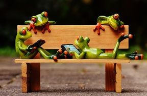 figures of frogs on a wooden bench