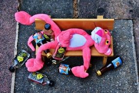 Pink Panther on a wooden bench with a bottle in his hand