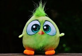 plush toy in the form of a bird on a black background