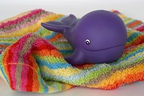 Toy whale on a striped towel