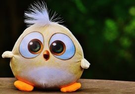yellow toy bird with a white forelock at blur green background