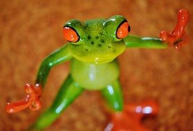 ceramic green frog with red paws are on the floor