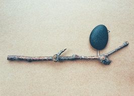 bird made of pebble stone on the branch