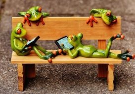 ceramic frogs relaxing in the bench