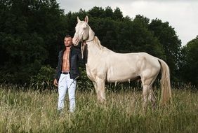 male model posing with a white horse