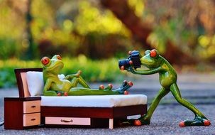 ceramic figures of frogs conduct a photo shoot