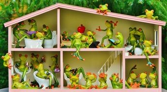 many different figures of frogs in a dollhouse