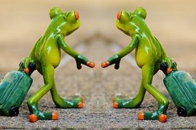 two toy Frogs with Travel Luggage stand Together