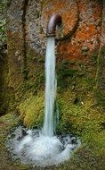 ancient rusted fountain, waterjet falling on moss