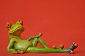 toy Frog Lying Relaxed at Red background