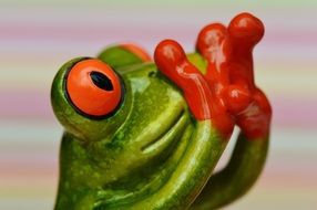 green frog covered her mouth with his red legs