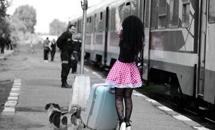 girl with luggage on a peron in monochrome image