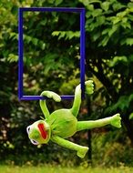 soft kermit hanging on picture frame