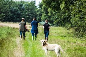 women with white labrador in a field