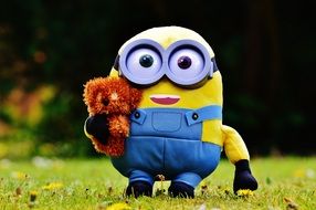 mignon with toy in hand on green grass with flowers