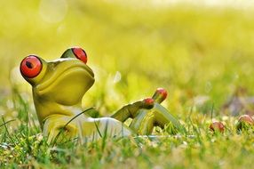ceramic frog figure resting in the grass