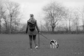 black and white photo of a girl with a dog in a meadow
