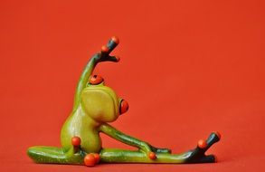 toy frog in yoga on red background