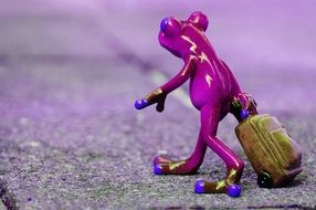 figurine of a purple frog with luggage