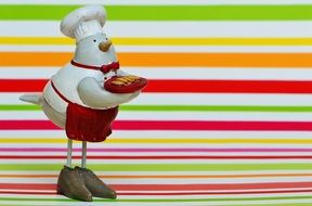 chicken in the form of a cook on a background of colored bands