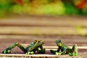 two multi-colored mosaic figures of frogs