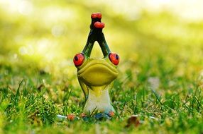 ceramic figure of a frog on the meadow