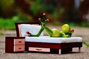 toy Frog lays on Bed outdoor