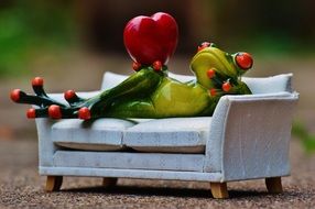 toy frog with a heart on a white sofa