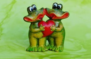 two ceramic frog with a heart in his hands