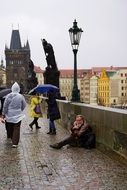 people on the carlo Bridge in Prague in the rain