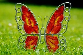 metal figure of a butterfly with glass close-up on blurred background