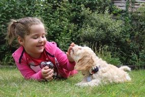 happy girl playing with the cute puppy among the plants