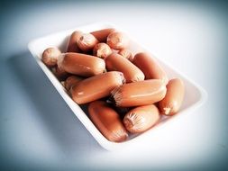 Sausage in the white bowl on the white surface