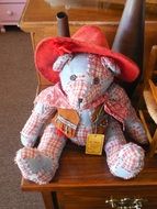 Teddy Bear in red hat, toy sitting on chair