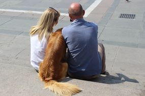 people and a dog sit on a stone step in Milan