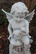 stone sculpture of Small angel with a bird