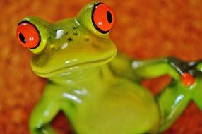 ceramic green frog with big red eyes