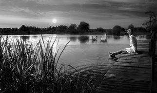 girl on the lake with swans black and white photo