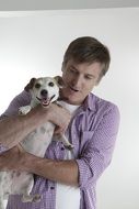 man holds a purebred dog in his arms