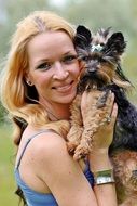 smiling Blonde Girl holding Yorkshire Terrier dog, portrait