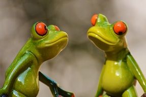 cute Funny ceramic Frogs close-up on blurred background