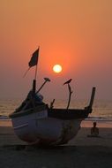 meditating girl and fishing boat on the beach in india
